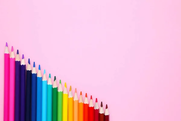 许多不同颜色的铅笔在粉红色的背景上 — 图库照片