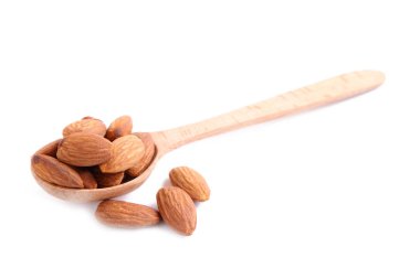 Tahta kaşıktaki bademler beyaz arkaplanda izole edilmiş.