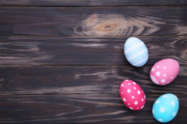 Kahverengi bir arka planda, düz renkli Paskalya yumurtalarını