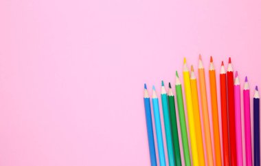 Many different colored pencils on pink background clipart