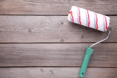 Gri ahşap arka plan üzerine boya rulosu