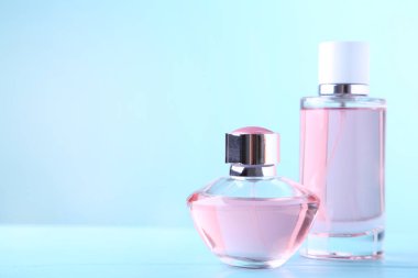 Mavi arka planda iki parfüm şişesi, üst görünüm