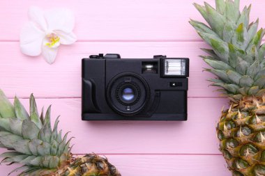 Pembe arka planda kamera ile iki olgun ananas