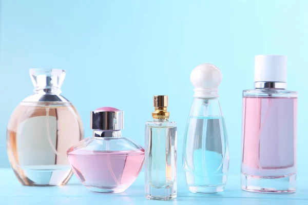 Perfume bottles on blue background, top view