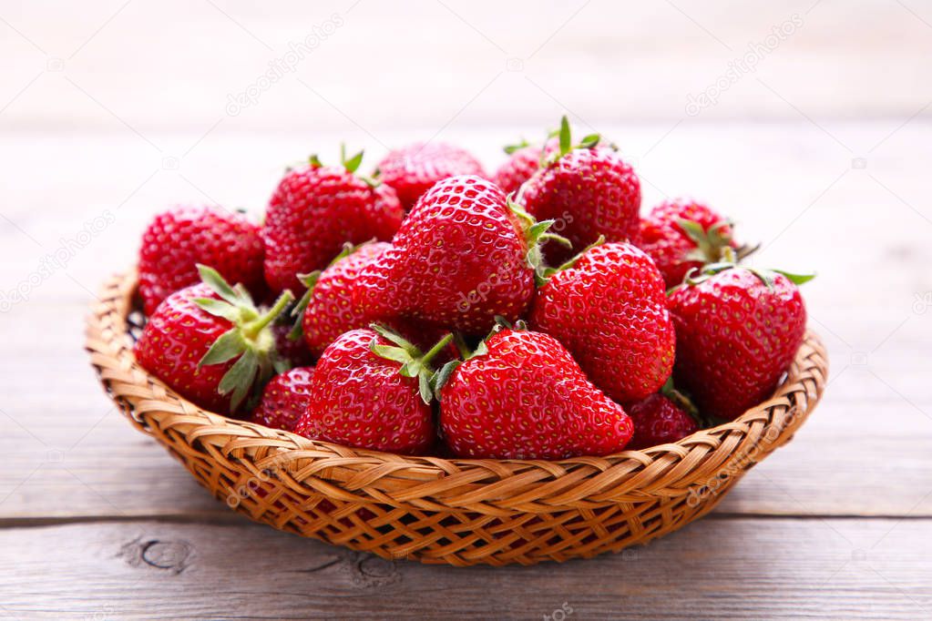 Strawberries in the basket on grey wooden background