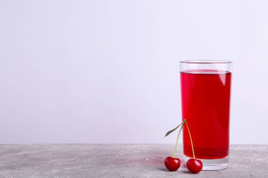 Kopya alanı ile gri arka planda kiraz suyu ve çilek Cam