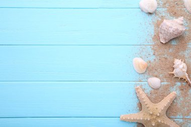 Denizyıldızı ve deniz kabukları, ahşap bir arka plan üzerinde kum. Yaz konsepti