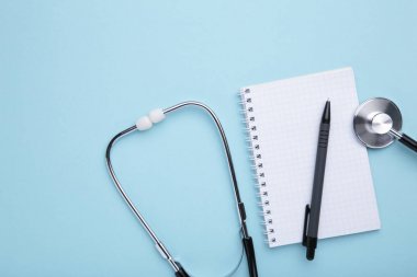 Stetoskop, mavi arka planlı dizüstü bilgisayar. Metniniz için yer olarak en iyi görünüm.
