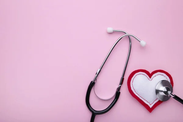 Stetoscopio e cuore su sfondo rosa. Salute, medicina — Foto Stock