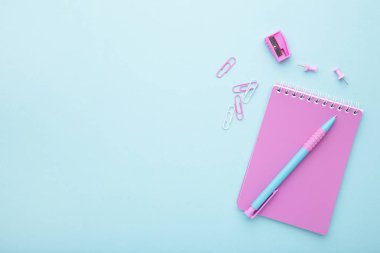 Mavi arka planda pembe okul aksesuarları. Okul konseptine geri dön.