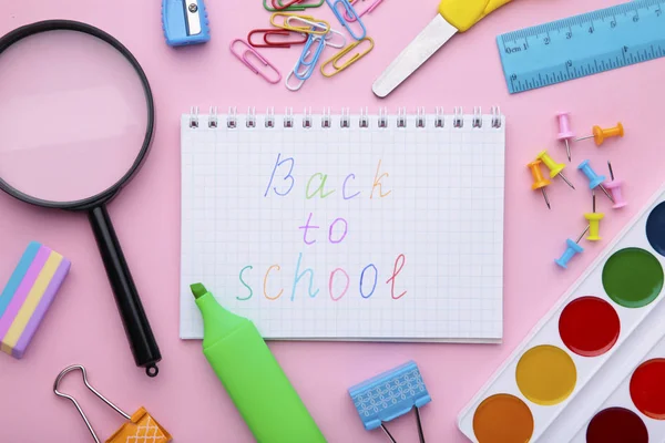 Inscription Back To School with school supplies on pink background