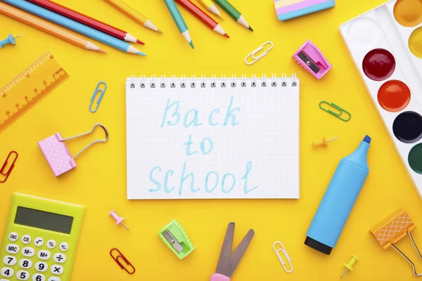 Inscripción Volver a la escuela con útiles escolares sobre fondo amarillo —  Fotos de Stock