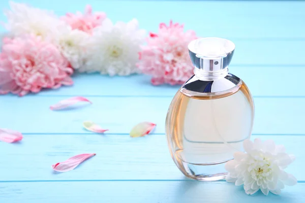 Fles parfum met witte bloemen op blauwe achtergrond — Stockfoto