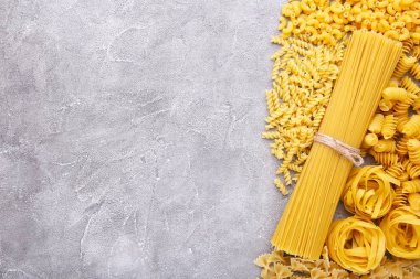 Gri beton arka plan üzerinde lezzetli karışık makarna, çerçeve