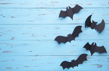 Mavi ahşap arka plan üzerinde Halloween kağıt yarasalar. Cadılar Bayramı konsepti, çerçeve