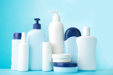 Mavi arka planda farklı kozmetik şişeler. Şişeler.