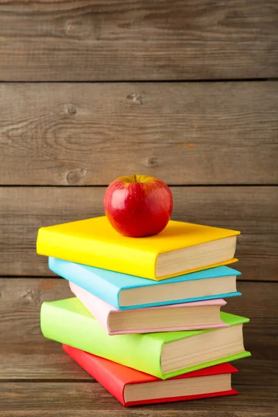 Composition of school books and an apple on grey wooden background. Top view