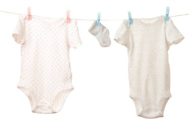Çamaşır ipine asılı bebek kıyafetleri beyazda izole edilmiş. Üst görünüm