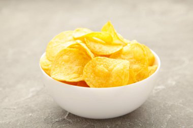 Patates cipsi kasede gri beton arka planda. Üst görünüm