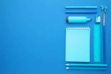 Mavi arka planda okul malzemeleri. Okula dönelim. Düz yatıyordu. Üst görünüm