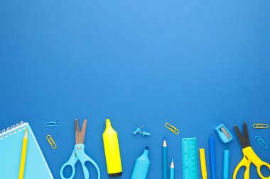 Mavi arka planda okul malzemeleri. Okula dönelim. Düz yatıyordu. Üst görünüm