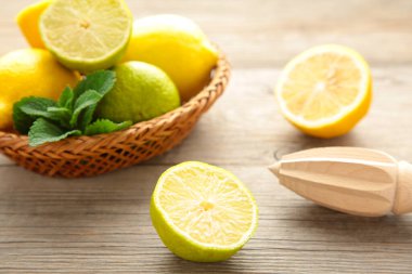Taze kireç ve limon sepsiyonunda turunçgil suyu sopa ile gri ahşap arka planda. Üst görünüm