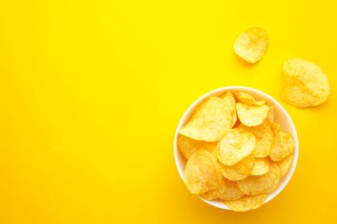 Sarı arka planda patates cipsi. Üst görünüm