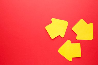 Kağıt yapışkan notlar kırmızı zemin üzerinde ok şeklinde. Üst görünüm