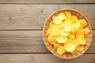 Gri ahşap arka planda patates cipsi sepeti. Üst görünüm