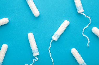 Mavi arka planda regl tamponları. Kadınlar için pamuk tampon. Üst görünüm