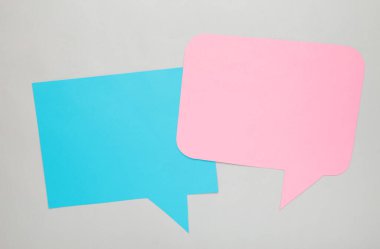 Diyalog: Gri arka planda iki boş konuşma balonu. Üst görünüm