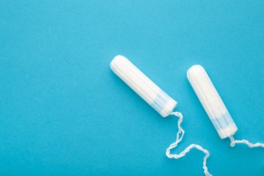 Mavi arka planda regl tamponları. Kadınlar için pamuk tampon. Üst görünüm