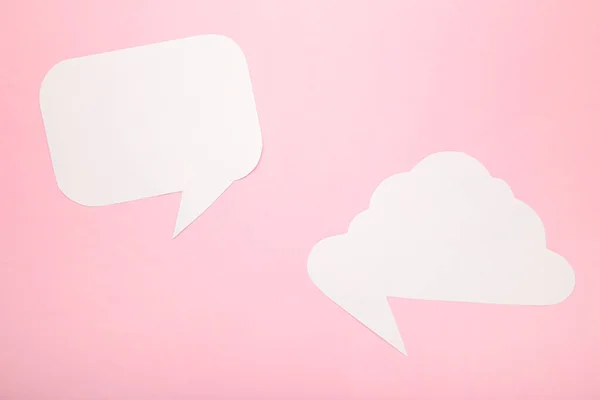 White paper speech bubbles on pink background. Top view