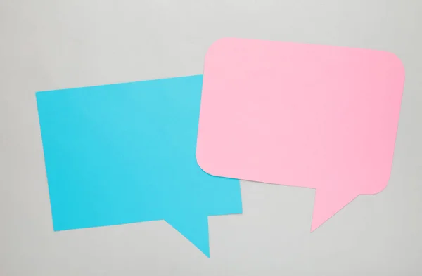 Dialog - two blank speech bubbles on grey backgrounnd. Top view