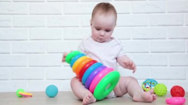 Renkli piramit oyuncağıyla oynayan tatlı bir kız bebek. Zeki komik çocuk. Üst görünüm