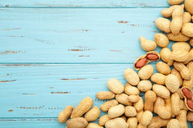 Mavi ahşap arka planda kabuklu fıstıklar. Üst görünüm