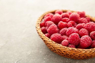 Gri beton arka planda sepetteki taze ahududu. Üst görünüm