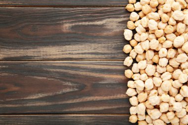 Kahverengi ahşap arka planda kurumuş organik nohut. Üst görünüm