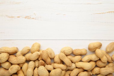 Beyaz ahşap arka planda kabuklu fıstıklar. Üst görünüm
