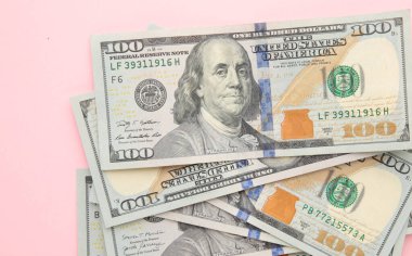 Pembe arka planda yığınla yüz dolar. Üst görünüm