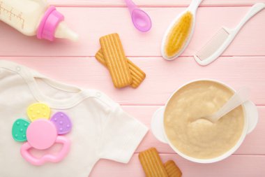 Pembe arka planda oyuncakları olan bebek mamasıyla bovling. Üst görünüm