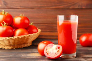 Kahverengi arka planda meyve suyu olan taze domatesler. Üst görünüm