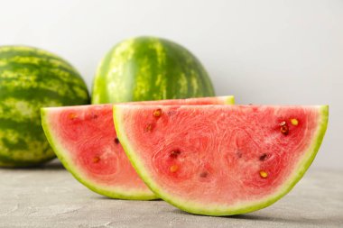 Gri arka planda taze çizgili dilimlenmiş karpuz. Üst görünüm