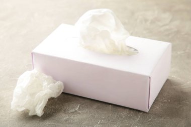 Kağıt mendilli kutu ve gri arka planda buruşmuş peçete kullanılmış. Üst görünüm