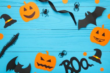 Halloween composition with spiders and bats on blue background. Top view clipart
