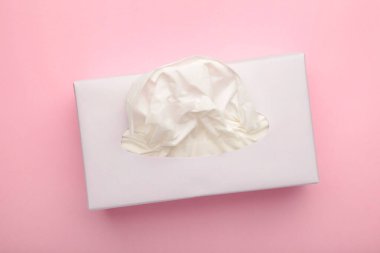 Pembe pastel arka planda kağıt mendilli bir kutu. Üst manzara.
