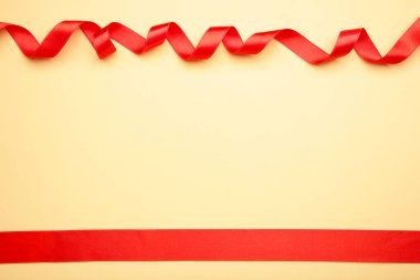 Bej arkaplanda fotokopi alanı olan parlak kırmızı kurdele. - Evet. Üst görünüm