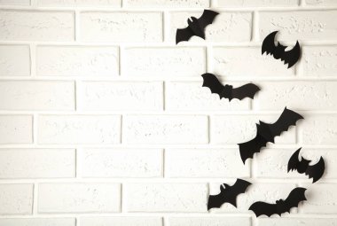 Cadılar Bayramı, dekorasyon ve korkunç konsept. Beyaz arka planda uçan siyah kağıt yarasalar.