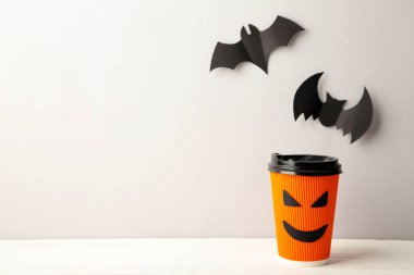 Cadılar Bayramı arkaplanında cadılar bayramı yarasaları olan kağıt bardak. Üst görünüm