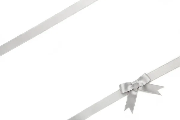銀リボンと弓の白い背景に隔離された トップ表示 — ストック写真